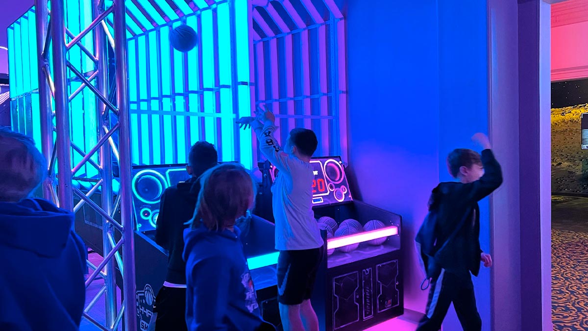 children throwing balls in neon lit room at Sports Room Beyond the Lens in Pigeon Forge, Tennessee, USA